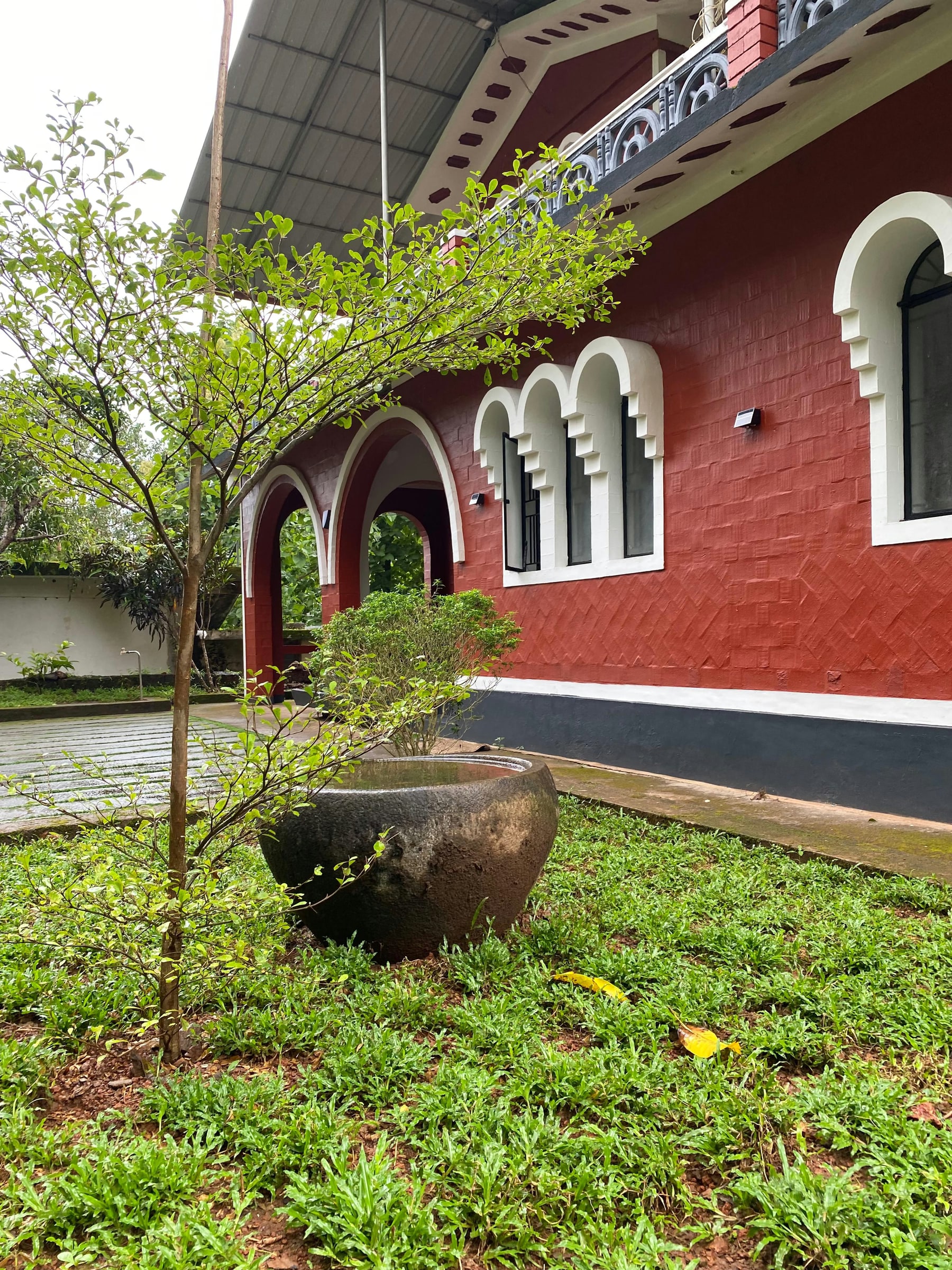 Garden corner and red exterior wall at Vysakham Heritage