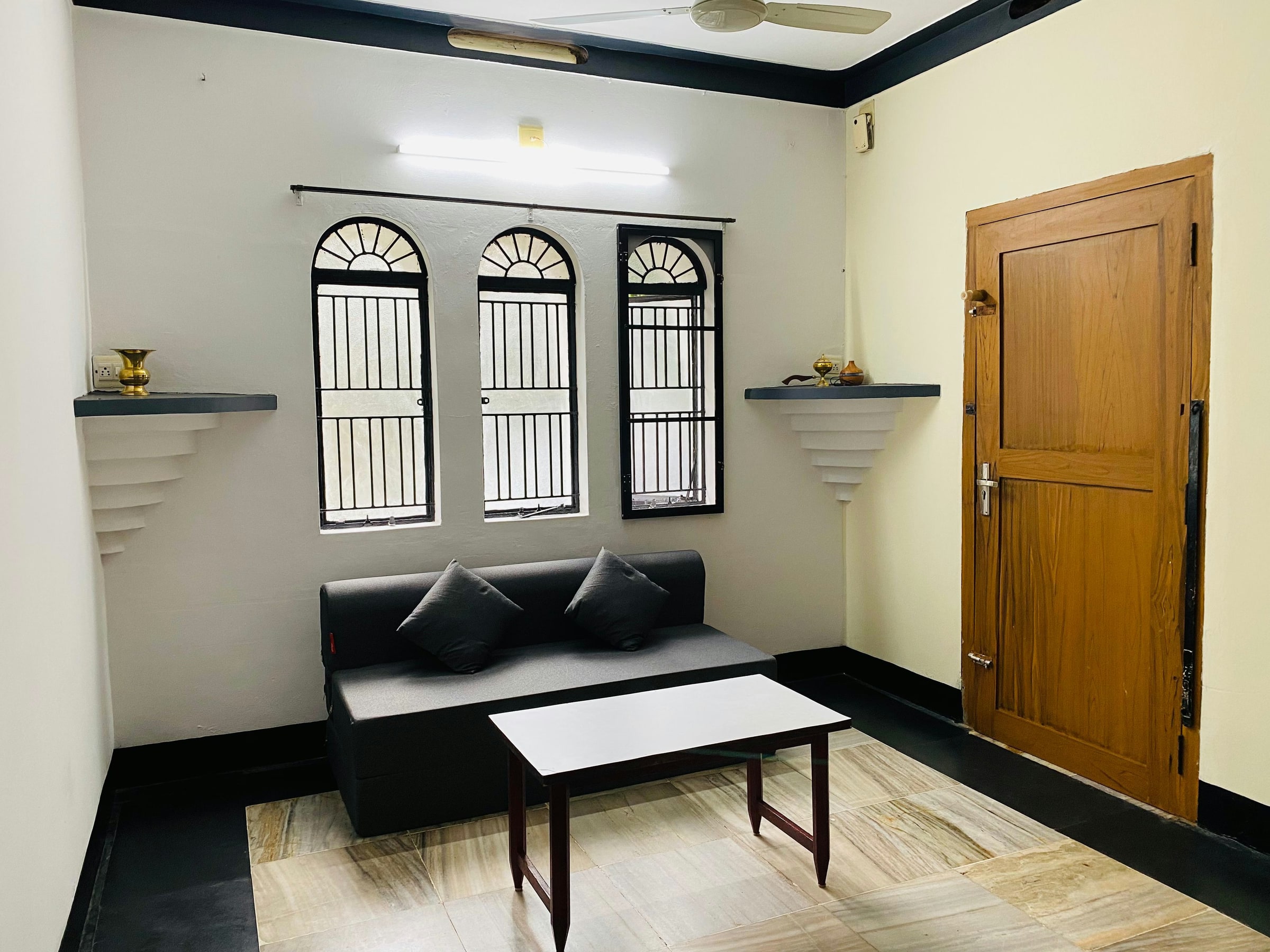 Living room with sofa, table, and arched windows